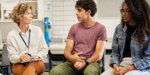 A counselor having a serious discussion with two high school students.