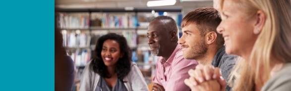 Group of adults watching a presentation in a library