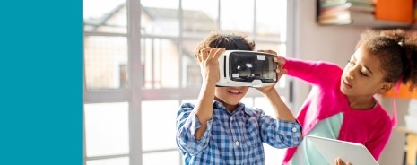 A female student helping a male student with a VR headset